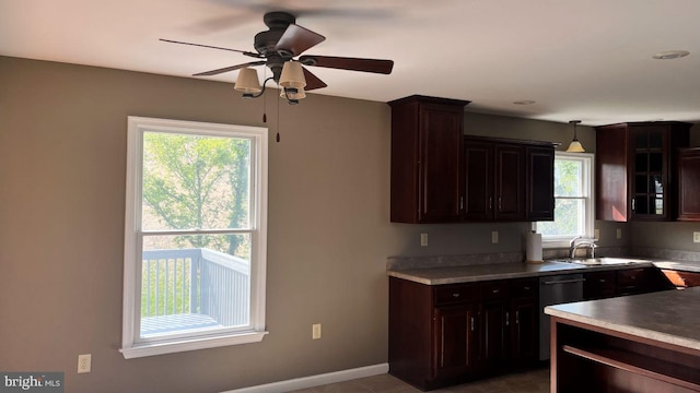 kitchen with hanging light fixtures, dark brown cabinetry, ceiling fan, sink, and black dishwasher