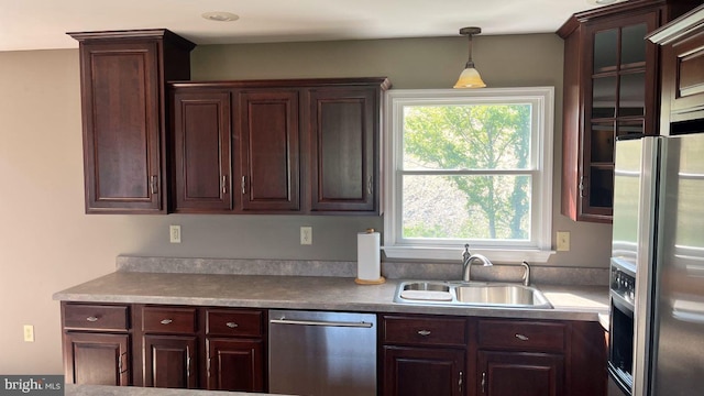 kitchen featuring dark brown cabinetry, pendant lighting, stainless steel appliances, and sink