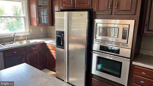 kitchen featuring appliances with stainless steel finishes, sink, and dark brown cabinets