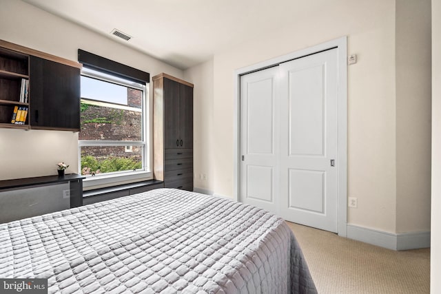 bedroom featuring light colored carpet and a closet