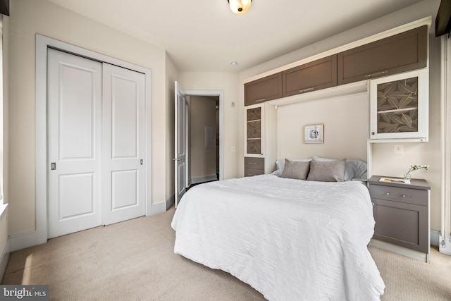 bedroom with light colored carpet and a closet