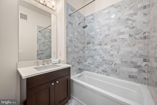 bathroom featuring vanity and tiled shower / bath