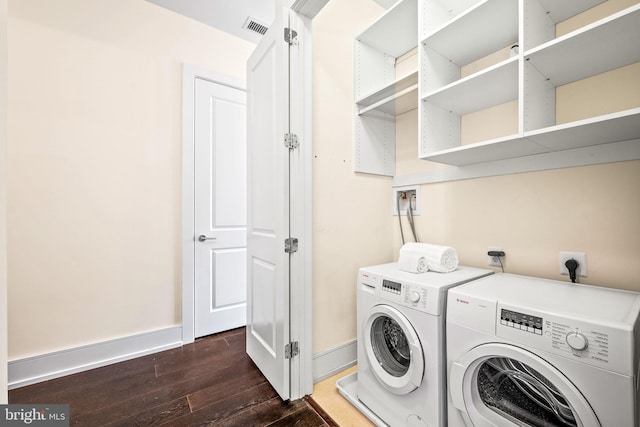 laundry room featuring dark hardwood / wood-style floors and washer and clothes dryer