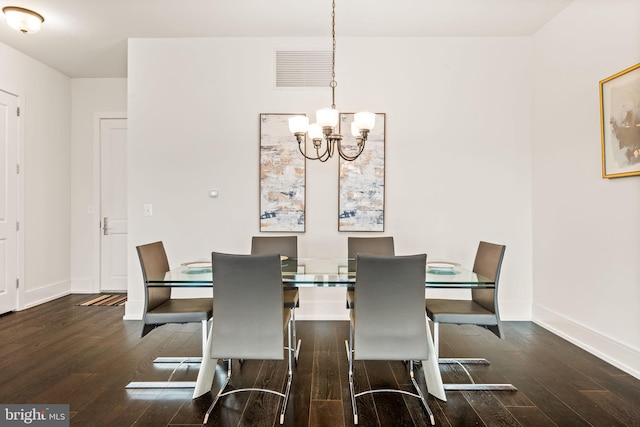 dining space with a notable chandelier and dark hardwood / wood-style flooring