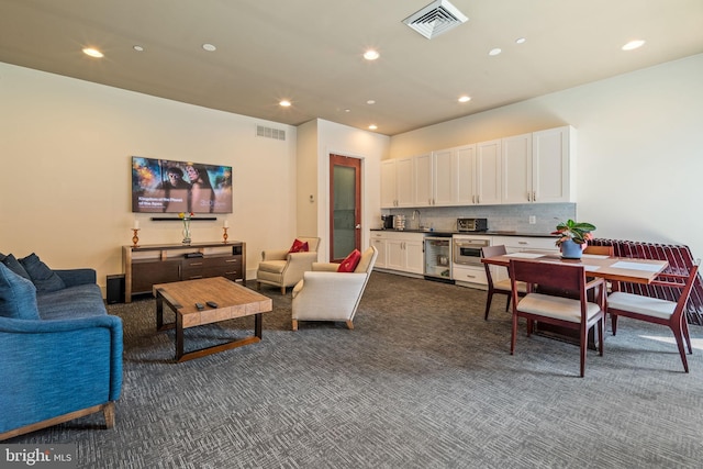 living room with sink, wine cooler, and dark carpet