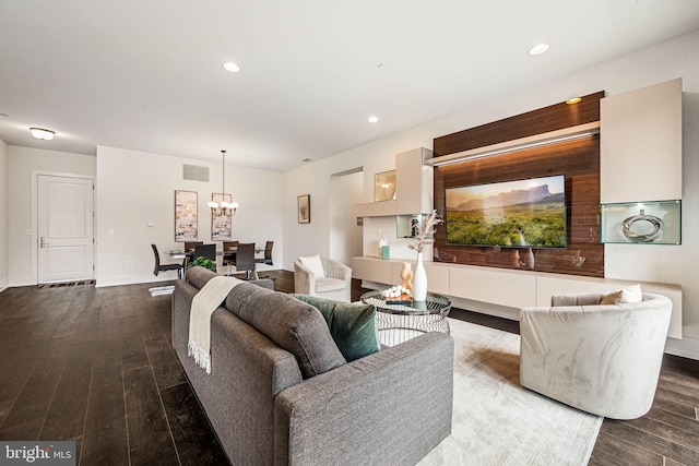 living room with a notable chandelier and dark hardwood / wood-style flooring