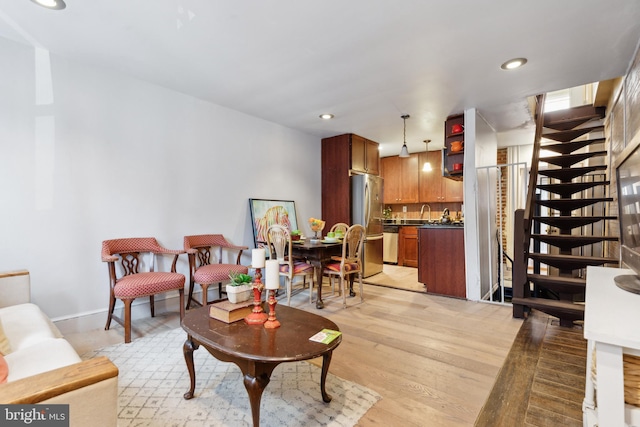 living area featuring stairway, light wood-type flooring, and recessed lighting