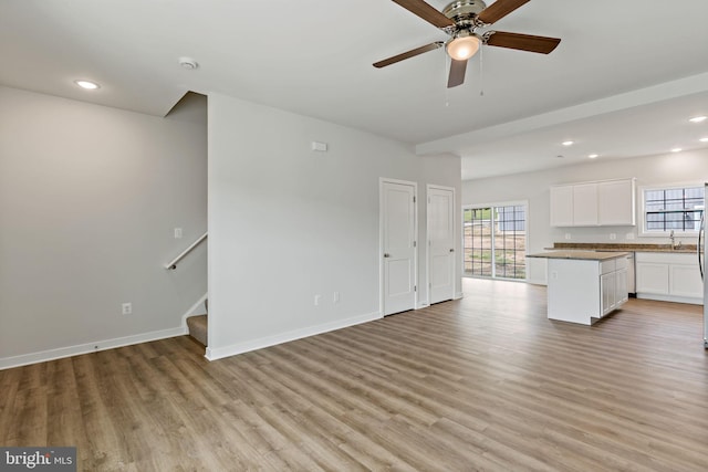 unfurnished living room featuring ceiling fan and light hardwood / wood-style floors