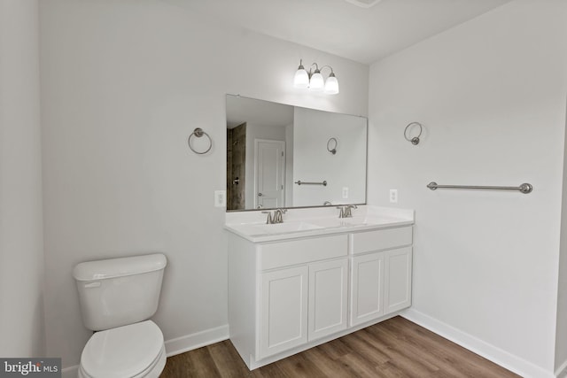 bathroom featuring vanity, hardwood / wood-style floors, and toilet