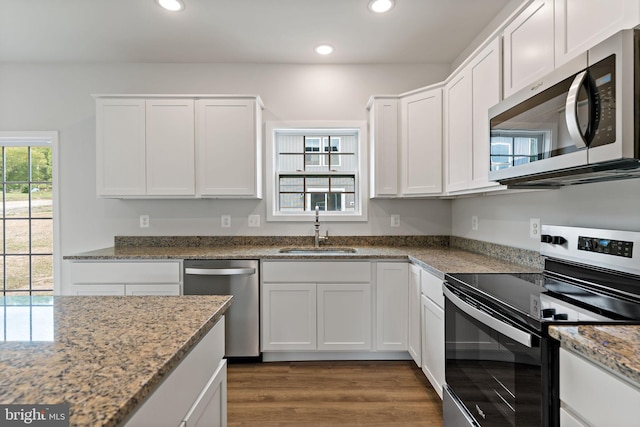 kitchen featuring sink, stainless steel appliances, white cabinets, and light stone countertops