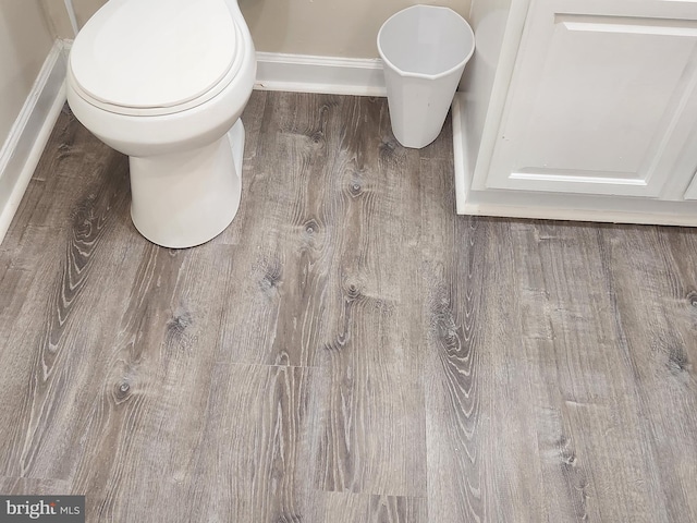 interior space with hardwood / wood-style floors and toilet