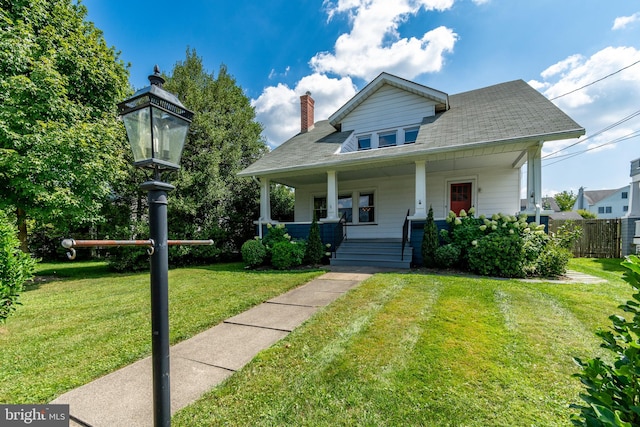 bungalow featuring covered porch and a front lawn