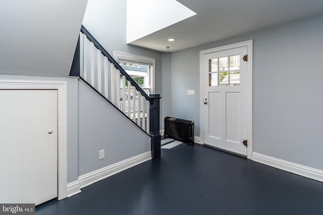 entryway with radiator, dark wood-type flooring, and plenty of natural light