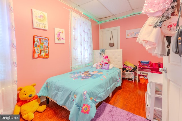 bedroom with hardwood / wood-style flooring and a drop ceiling