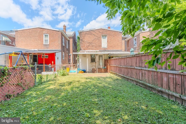 rear view of house featuring a yard