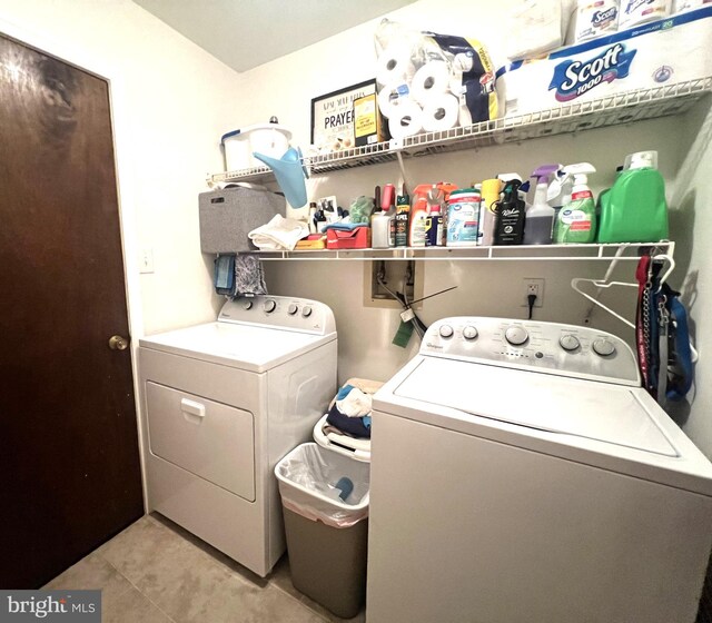 washroom with light tile patterned floors and washer and clothes dryer