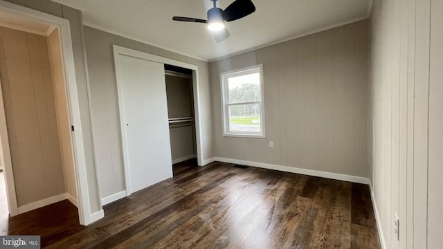 unfurnished bedroom featuring a closet, ceiling fan, ornamental molding, and dark hardwood / wood-style floors