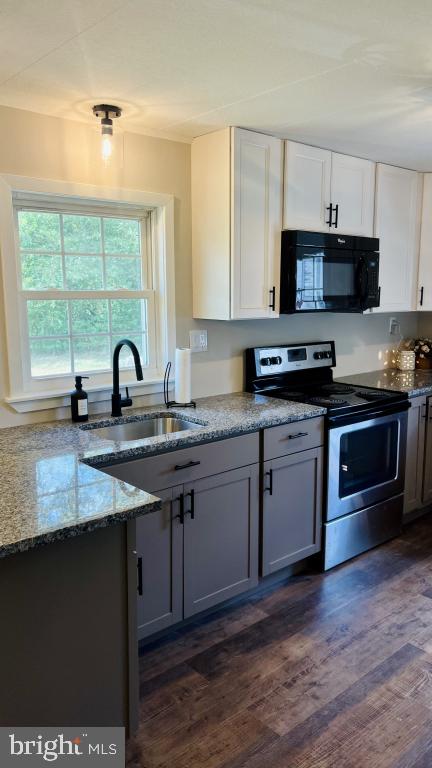 kitchen featuring dark hardwood / wood-style floors, white cabinetry, stainless steel range with electric cooktop, and sink