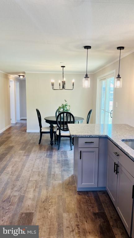 kitchen with decorative light fixtures, dark hardwood / wood-style floors, and light stone countertops