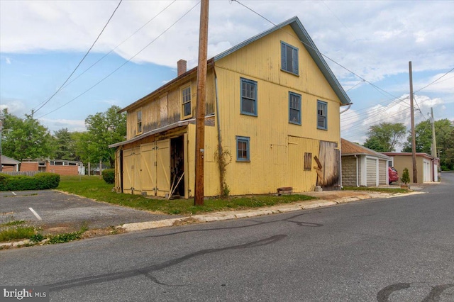 view of property exterior with an outbuilding