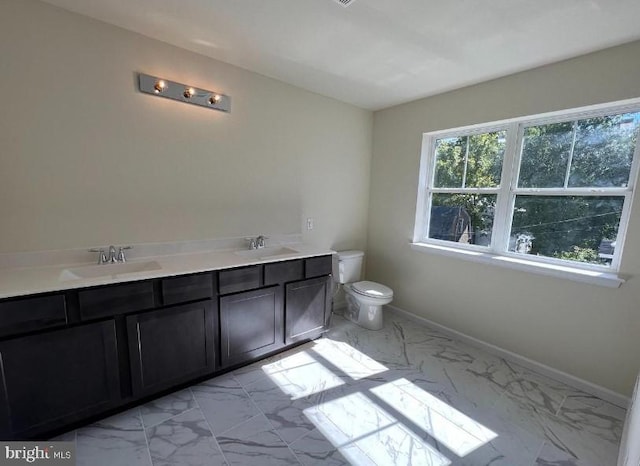 bathroom with a sink, baseboards, toilet, and marble finish floor