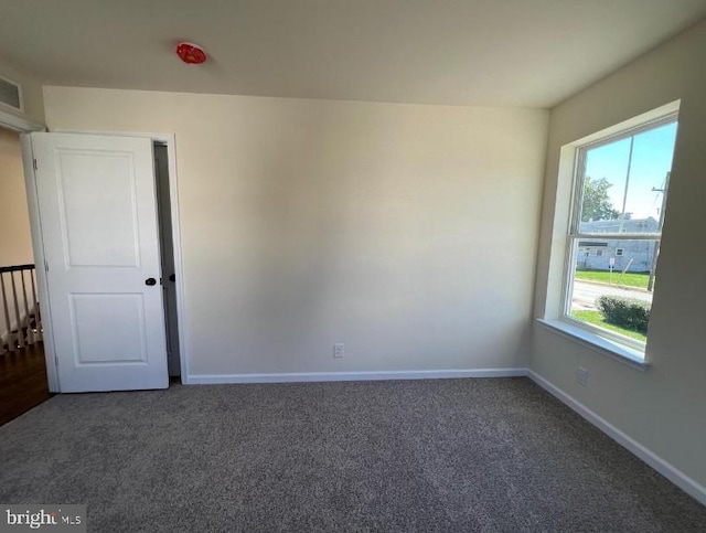 carpeted empty room featuring baseboards