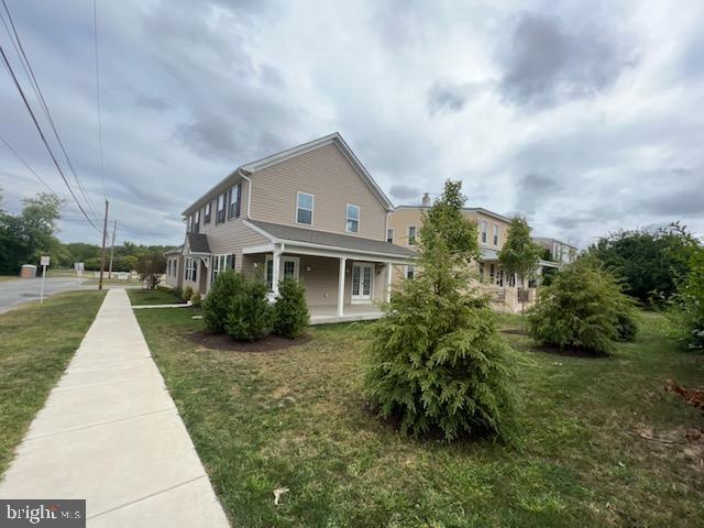 view of side of property with a lawn and a porch