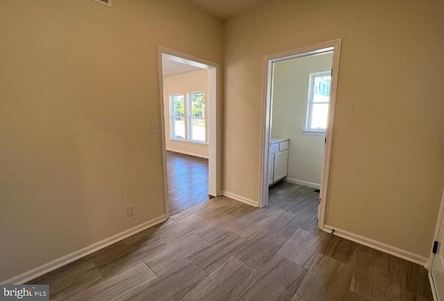 unfurnished room with baseboards and dark wood-style floors