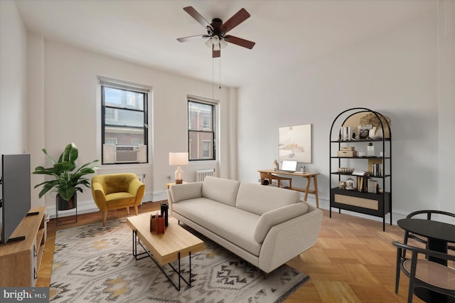 living room featuring light parquet floors, cooling unit, radiator heating unit, and ceiling fan