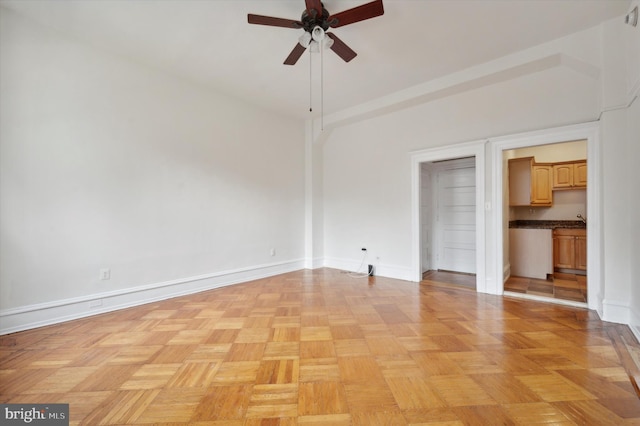 unfurnished bedroom featuring ceiling fan, light parquet floors, and a high ceiling