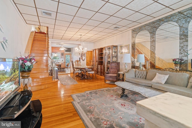 living room featuring ceiling fan with notable chandelier and hardwood / wood-style floors