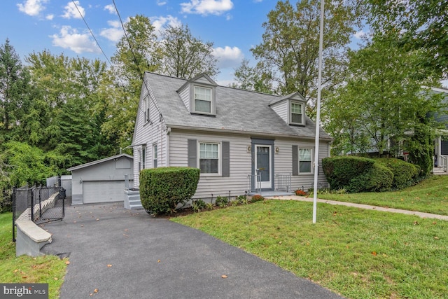 cape cod-style house with an outbuilding, a front lawn, and a garage