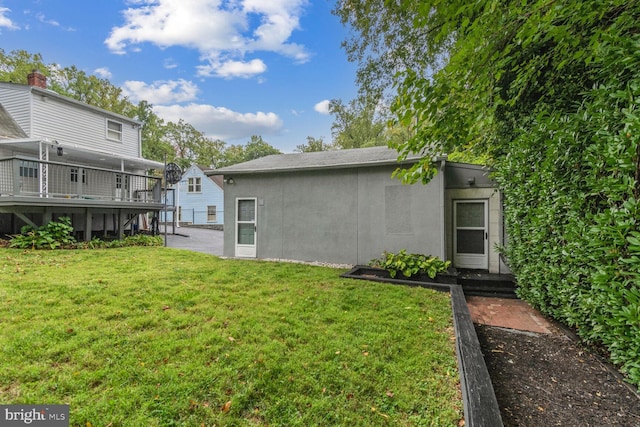 back of property featuring a yard and a wooden deck