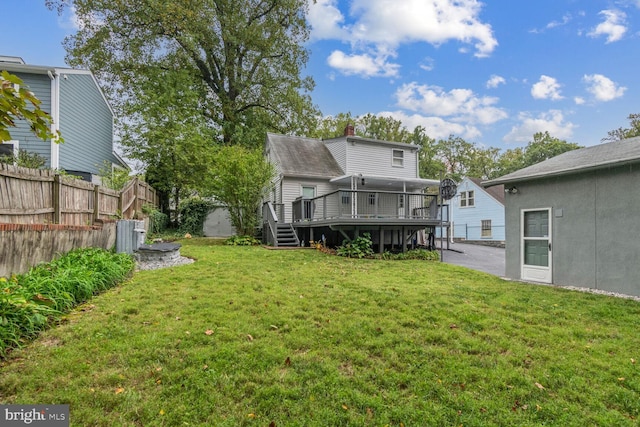 rear view of property featuring a yard and a wooden deck