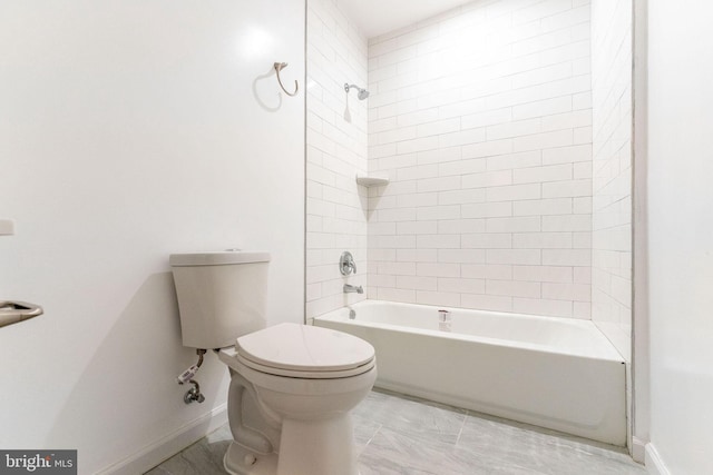 bathroom featuring tiled shower / bath combo and toilet