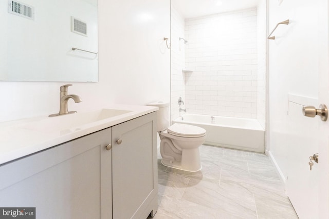 full bathroom featuring tiled shower / bath, vanity, and toilet