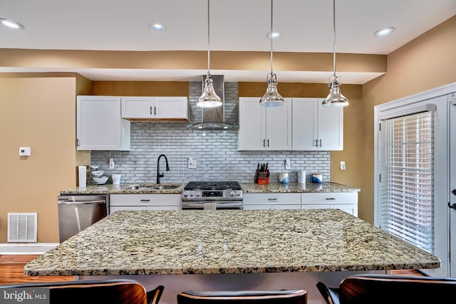 kitchen featuring white cabinetry, appliances with stainless steel finishes, a kitchen bar, and sink