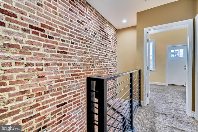 corridor with brick wall and carpet