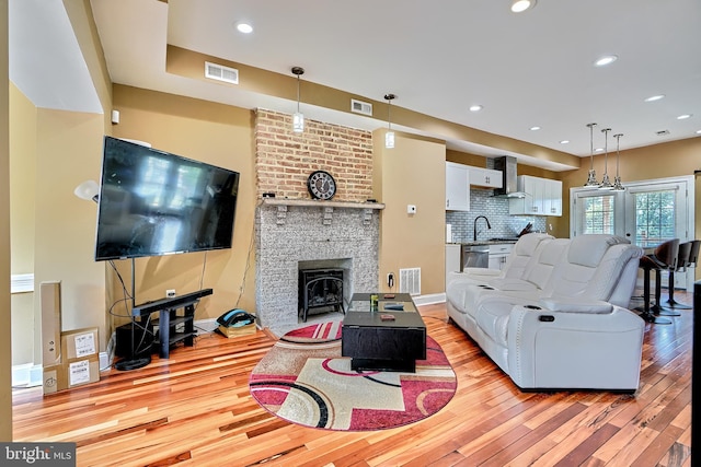 living room with sink, light hardwood / wood-style floors, and french doors