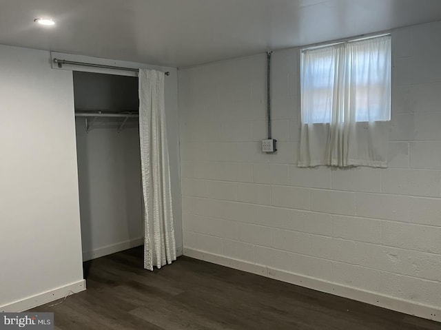 unfurnished bedroom featuring dark hardwood / wood-style floors and a closet