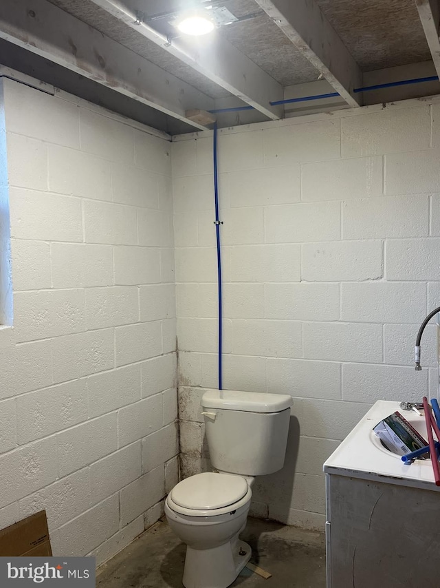 bathroom with vanity, toilet, and concrete flooring