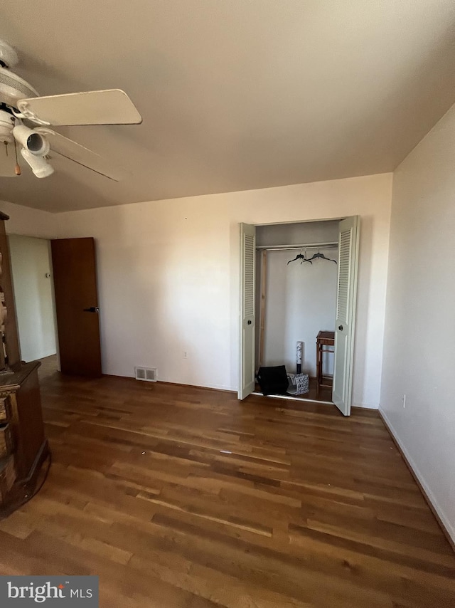 unfurnished living room with dark hardwood / wood-style floors and ceiling fan