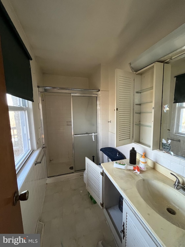 bathroom with vanity and a shower with shower door