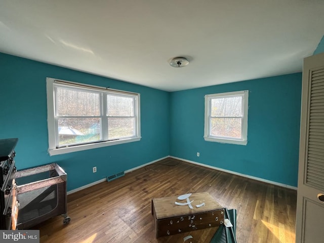 unfurnished bedroom featuring dark hardwood / wood-style flooring and multiple windows