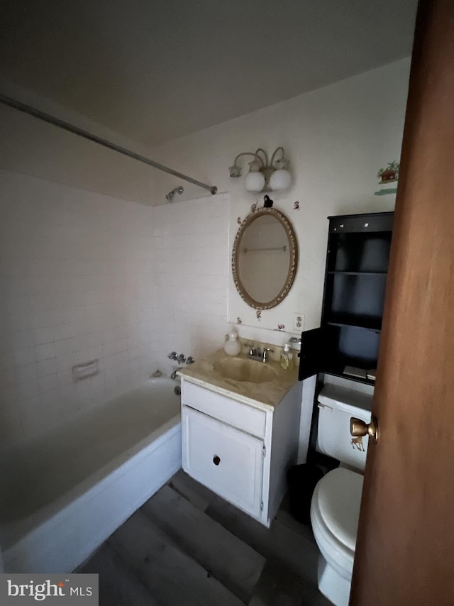 full bathroom featuring vanity, tiled shower / bath combo, and toilet