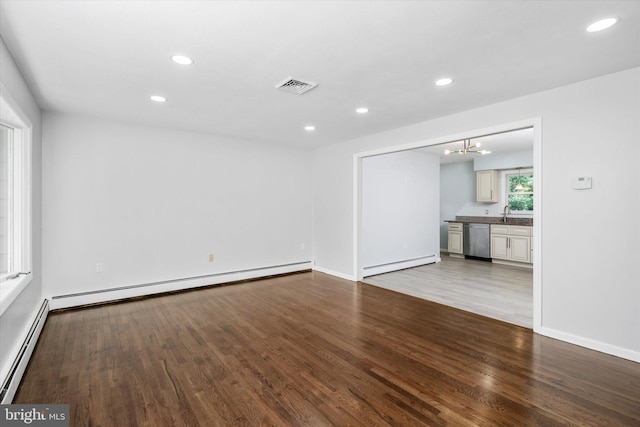 interior space with baseboard heating, light wood-type flooring, and an inviting chandelier