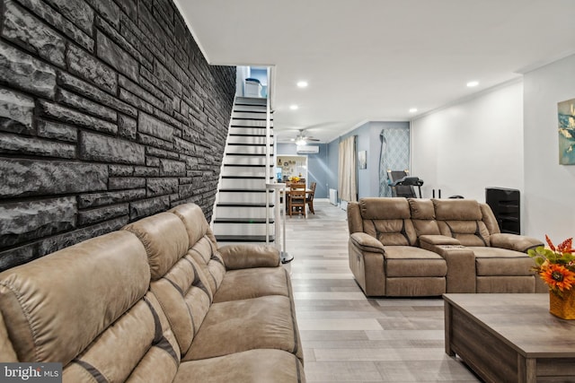 living room featuring ceiling fan, crown molding, and light wood-type flooring