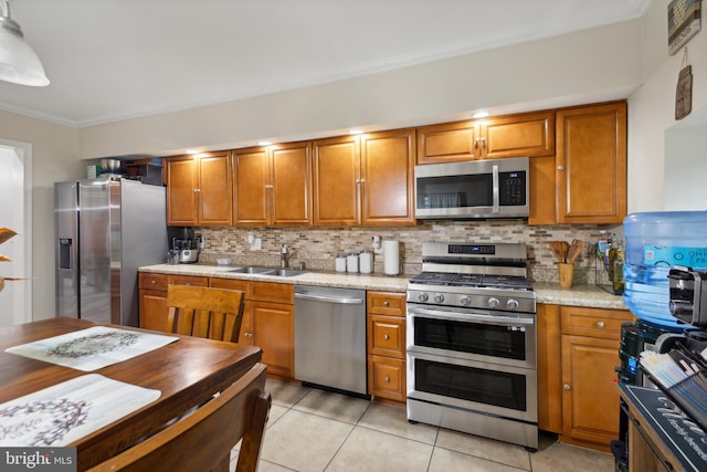 kitchen featuring light tile patterned flooring, stainless steel appliances, light stone counters, sink, and decorative backsplash