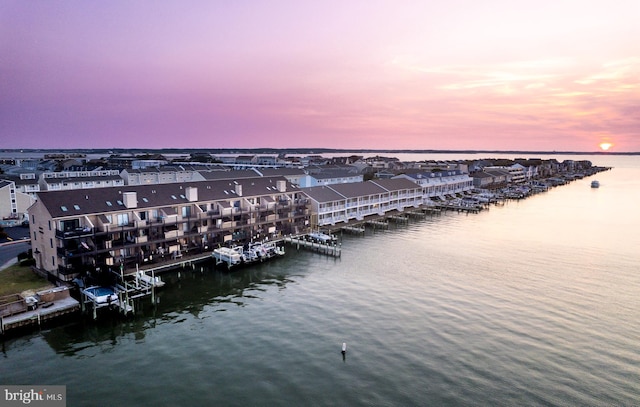 aerial view at dusk featuring a water view