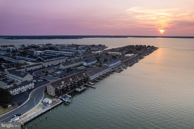 aerial view at dusk featuring a view of city and a water view